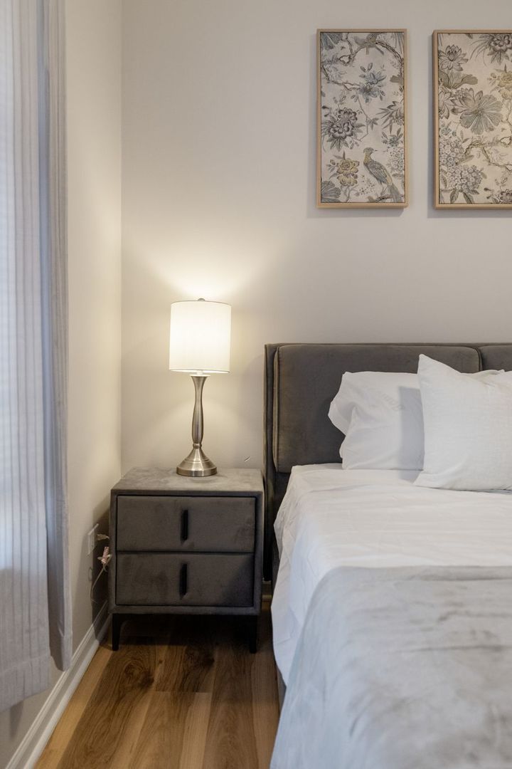 8232 Concord Lane, Unit B Justice, IL 60458 - Photo 28 of 32 a bed sitting in a bedroom next to a lamp