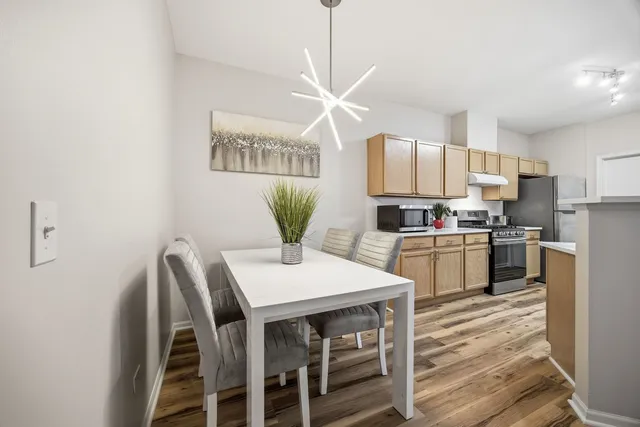 a kitchen with a table chairs refrigerator and cabinets