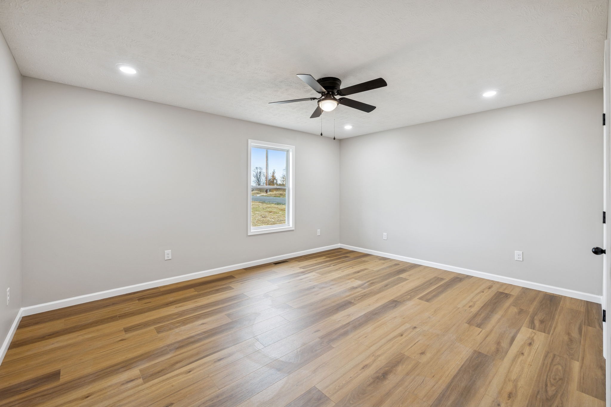 2649 Oak Knob Road Lafayette, TN 37083 - Photo 14 of 34 an empty room with wooden floor fan and windows