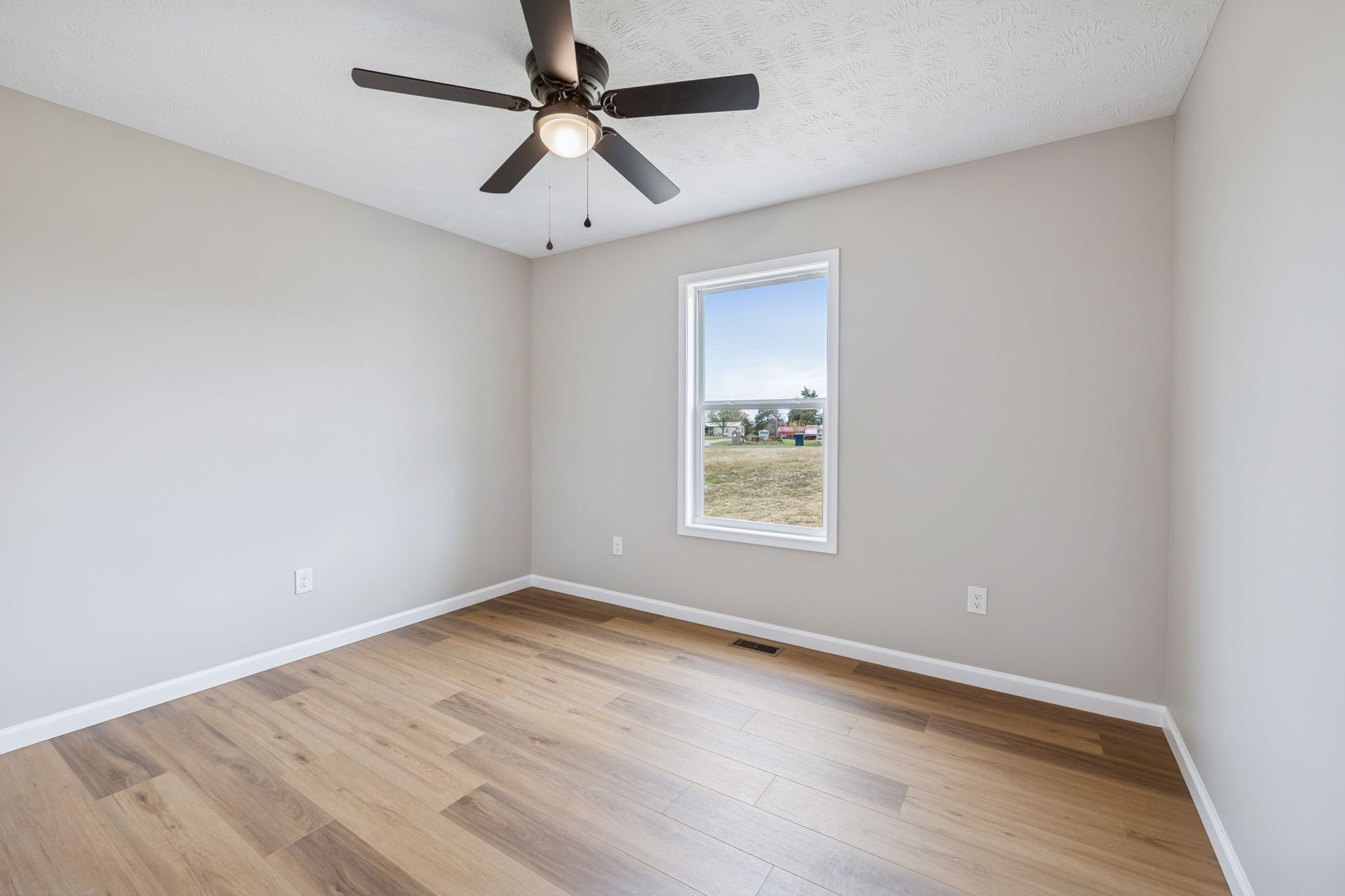 2649 Oak Knob Road Lafayette, TN 37083 - Photo 25 of 34 an empty room with wooden floor ceiling fan and windows