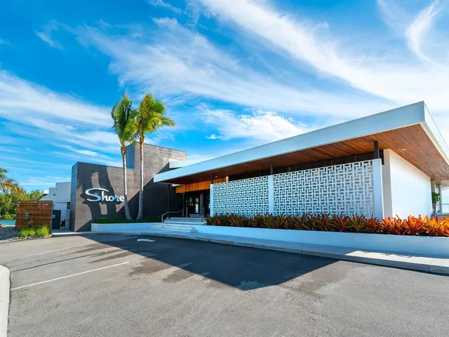a front view of a house with a yard and potted plants