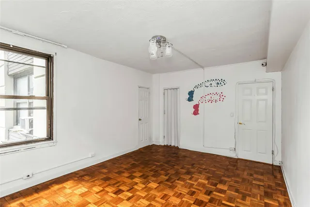 a view of a livingroom with a chandelier fan and wooden floor