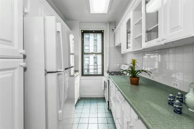 a kitchen with a sink a window and potted plant
