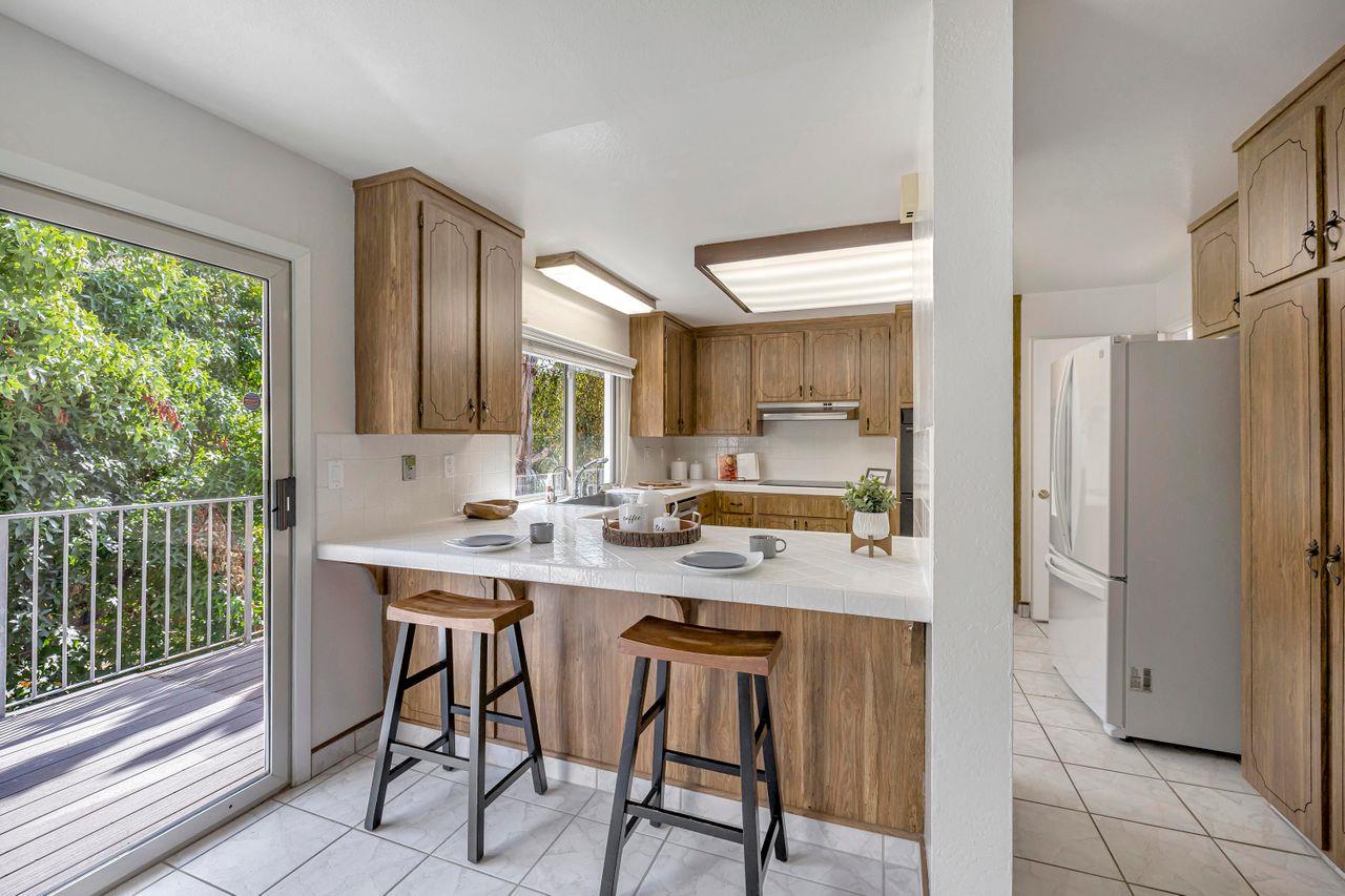 431 Green Hills Drive Millbrae, CA 94030 - Photo 16 of 50 a kitchen with stainless steel appliances a table chairs refrigerator and sink