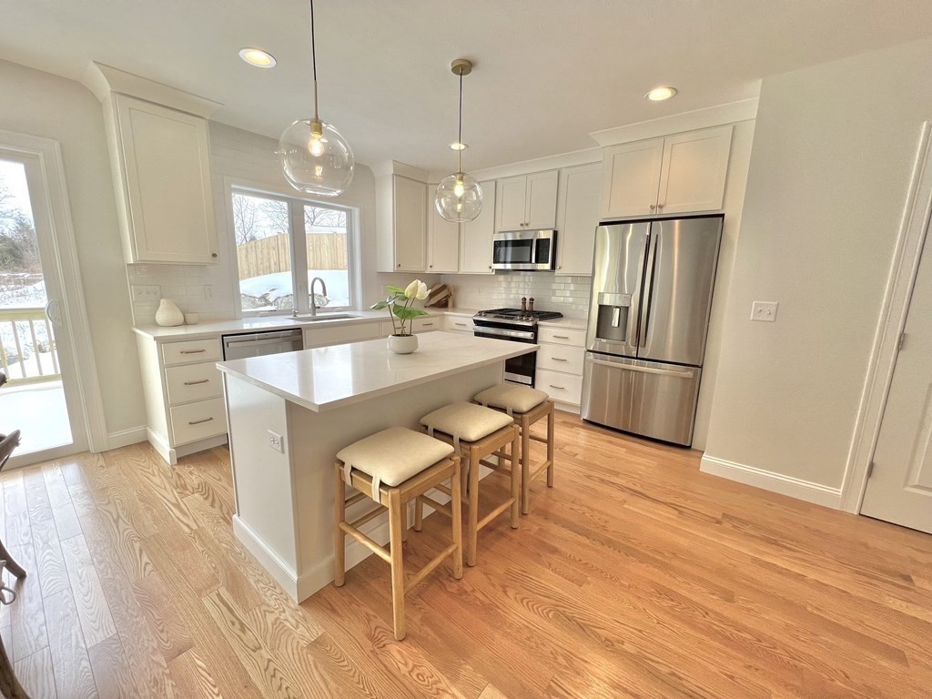 23 Sandy Pond Road, Unit 23 Ayer, MA 01432 - Photo 6 of 26 a kitchen with stainless steel appliances a dining table chairs stove refrigerator and cabinets