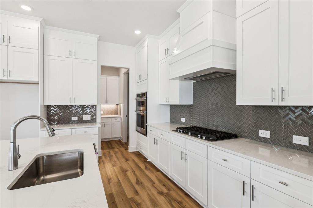 1608 Angus Trail Van Alstyne, TX 75495 - Photo 3 of 24 a kitchen with stainless steel appliances a sink a stove and cabinets