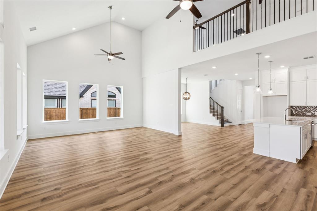 1608 Angus Trail Van Alstyne, TX 75495 - Photo 5 of 24 a view of an empty room with wooden floor and a kitchen