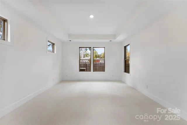 a view of a big room with windows and chandelier fan