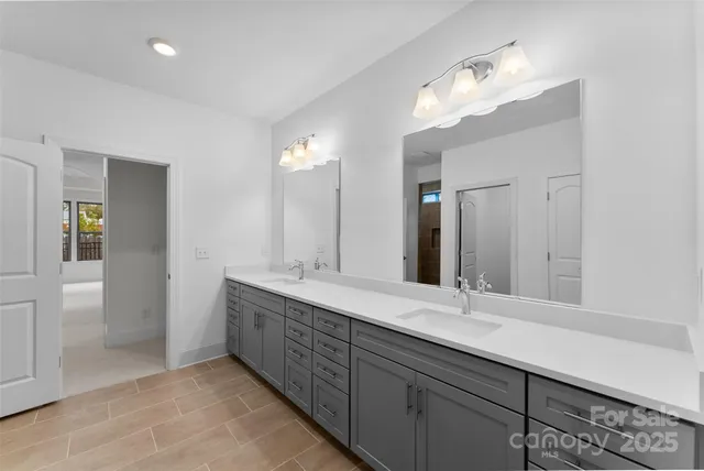 a bathroom with double vanity sinks and a mirror