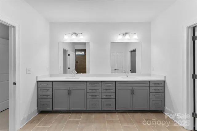 a spacious bathroom with a double vanity sink and a mirror