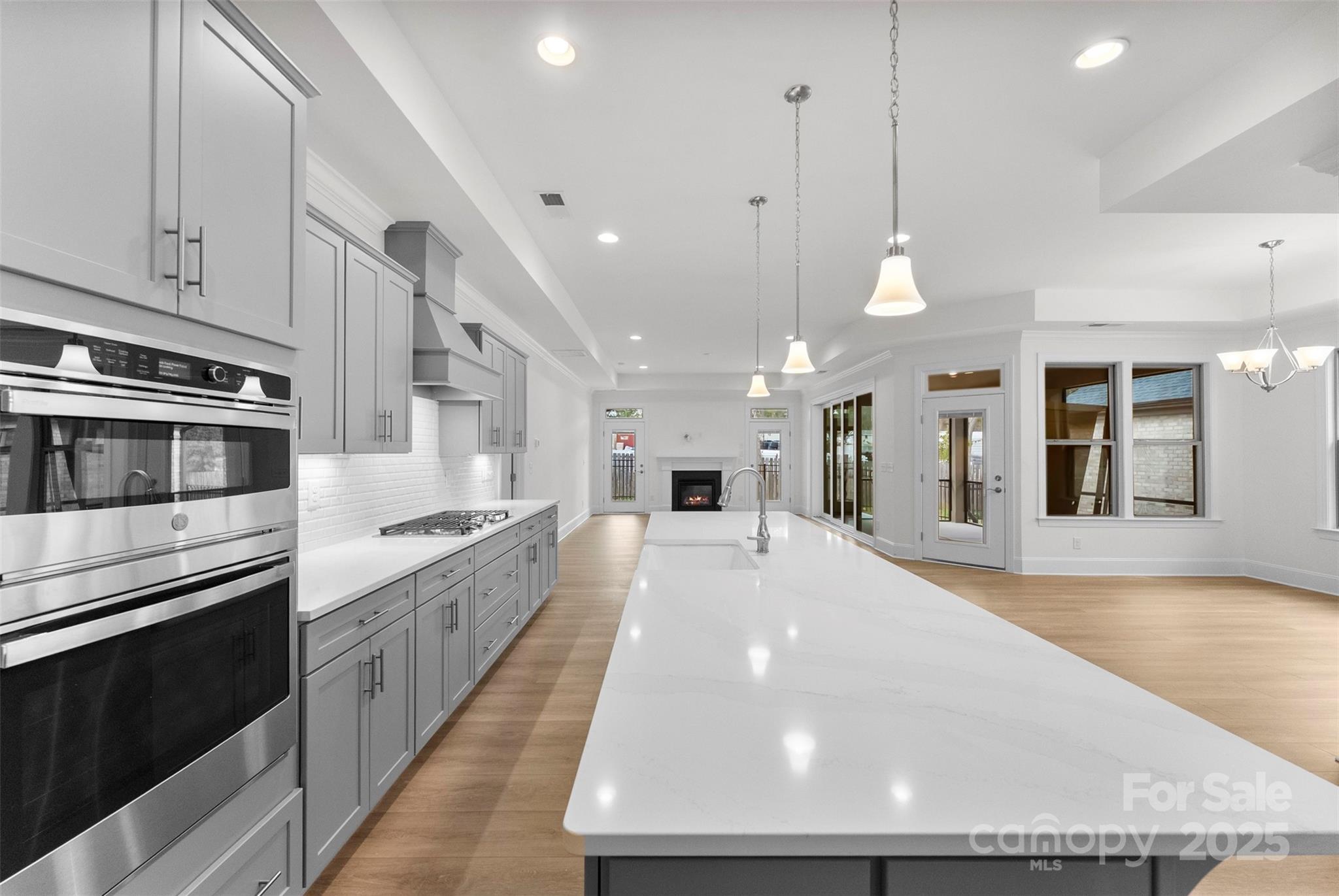 415 Newstyle Way Gastonia, NC 28056 - Photo 4 of 26 a large kitchen with kitchen island a stove a sink a refrigerator and a fireplace