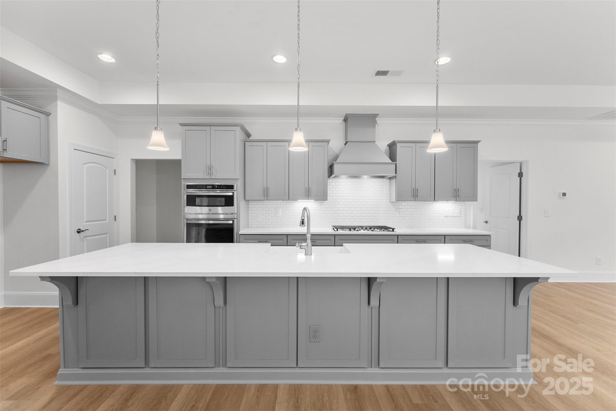 415 Newstyle Way Gastonia, NC 28056 - Photo 7 of 26 a large kitchen with kitchen island a large counter top stainless steel appliances and cabinets