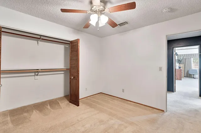 a bedroom with a bed and a ceiling fan