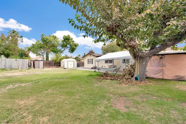 a view of a house with backyard and sitting area