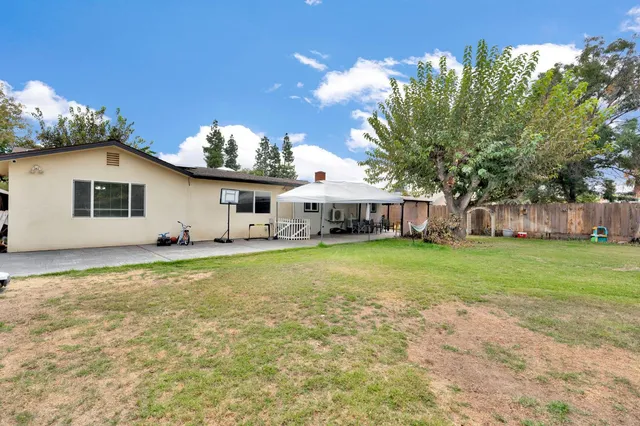 a view of a house with backyard and sitting area