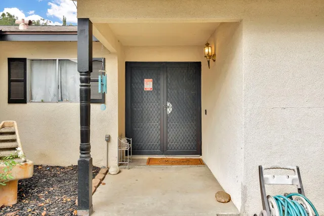 a view of a hallway with wooden floor and a bathroom