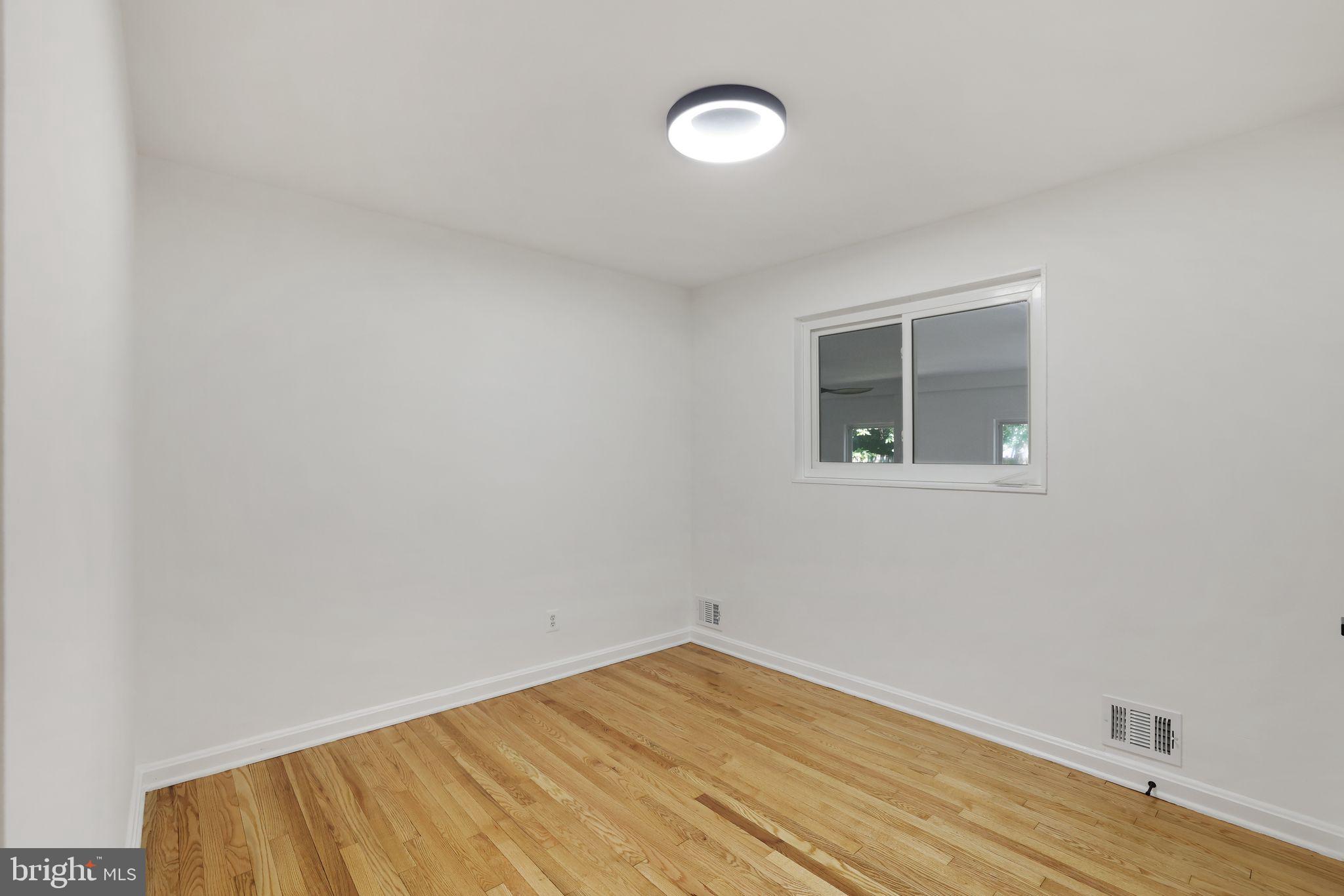 2423 Homestead Drive Silver Spring, MD 20902 - Photo 15 of 45 a view of an empty room with wooden floor and a window