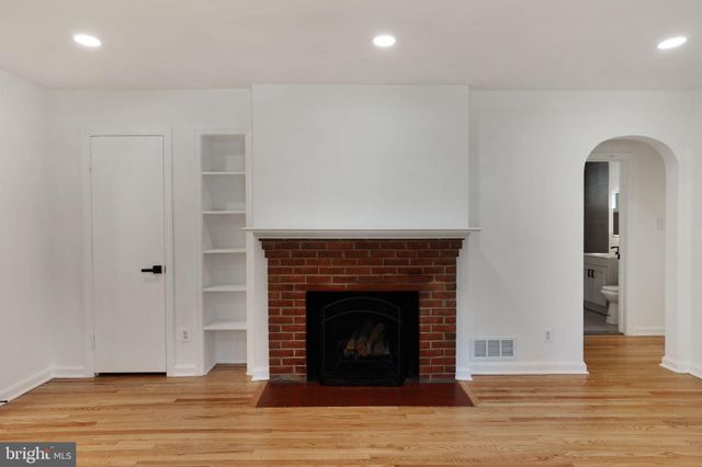 a living room with a fireplace and wooden floor