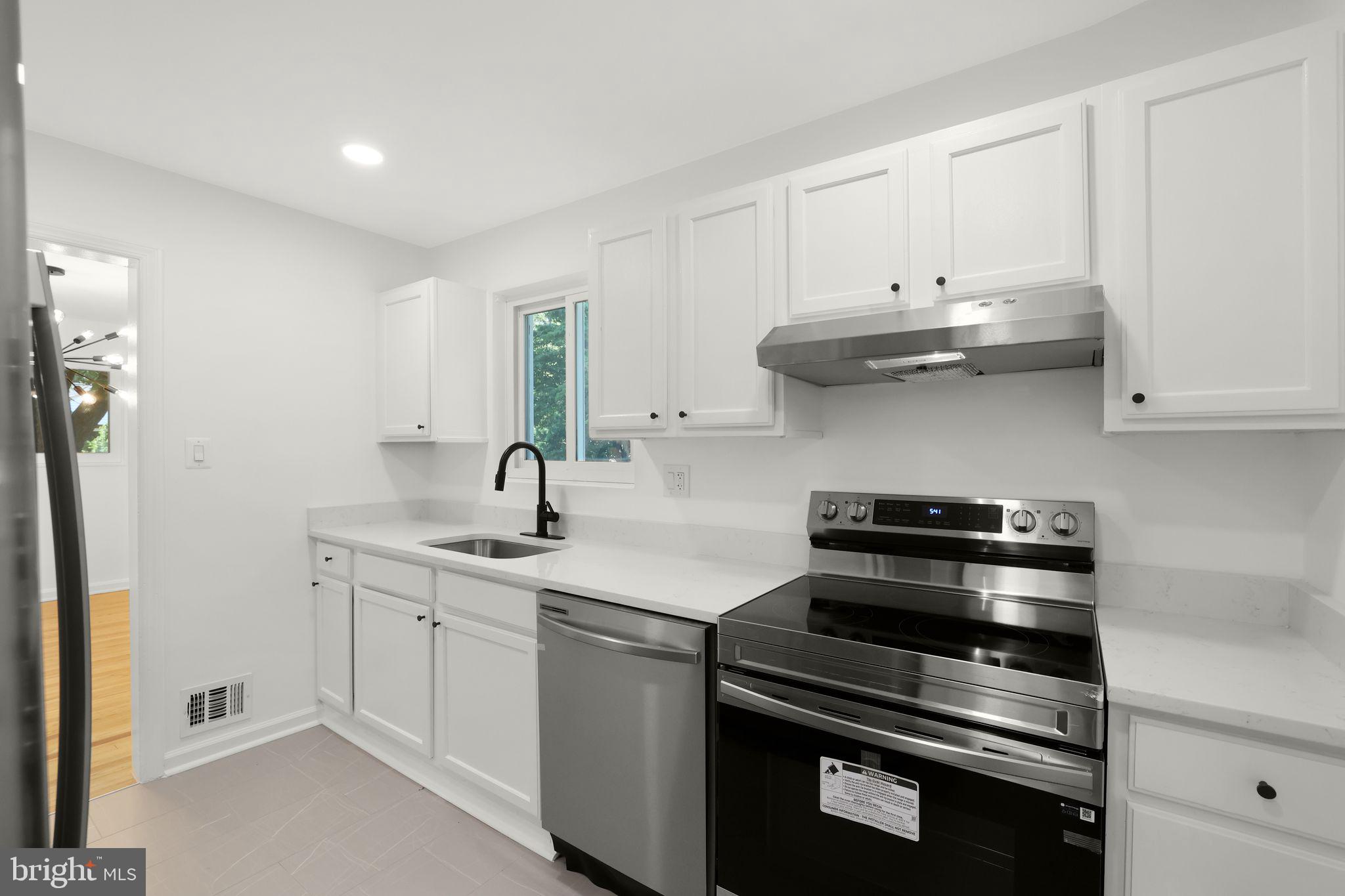 2423 Homestead Drive Silver Spring, MD 20902 - Photo 25 of 45 a kitchen with stainless steel appliances granite countertop a sink and cabinets