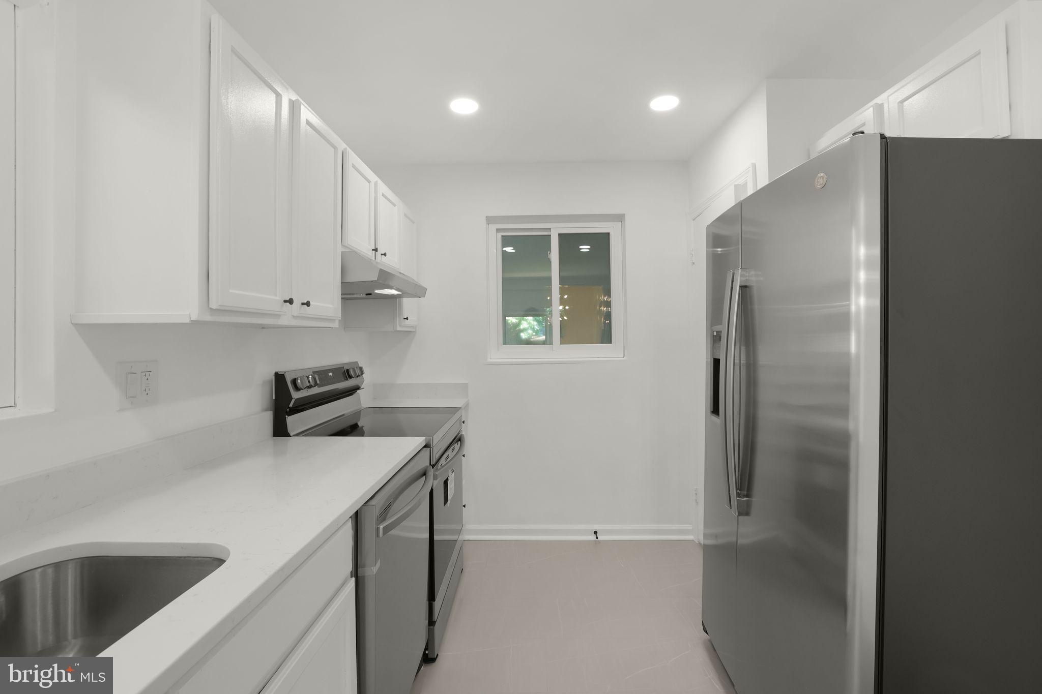 2423 Homestead Drive Silver Spring, MD 20902 - Photo 30 of 45 a kitchen with a sink a refrigerator and cabinets