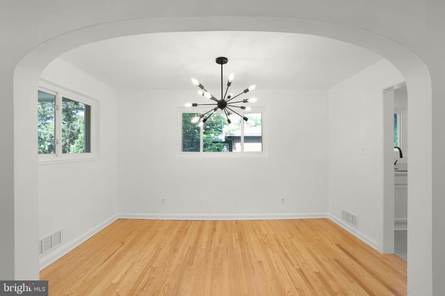 a view of empty room with window and wooden floor