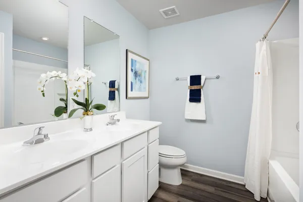 a en suite bathroom with a double vanity sink and a mirror