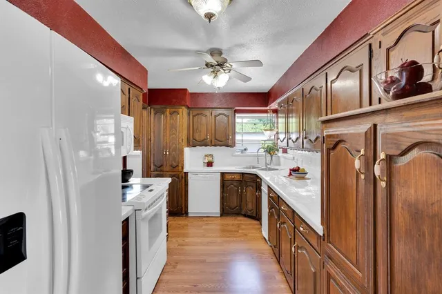 a kitchen with stainless steel appliances a refrigerator a stove a sink dishwasher and cabinets with wooden floor