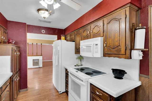 a kitchen with stainless steel appliances a stove a refrigerator a sink and dishwasher