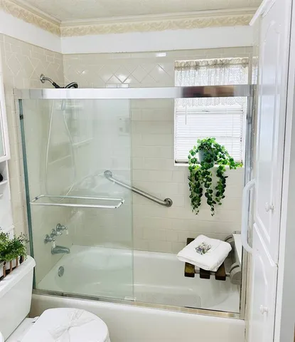 a bathroom with a shower and a white bath tub