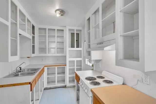 a kitchen that has a sink and a stove in it