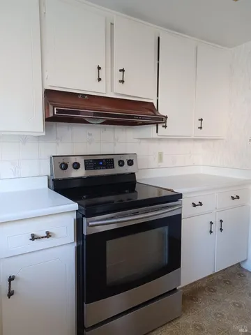 a stove top oven sitting inside of a kitchen