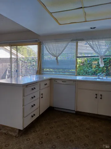 a kitchen with a sink window and cabinets