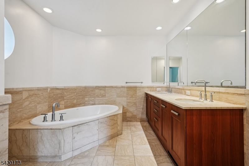 8100 River Road, Unit 210 North Bergen, NJ 07047 - Photo 14 of 25 a large bathroom with a double vanity sink a mirror and a bathtub