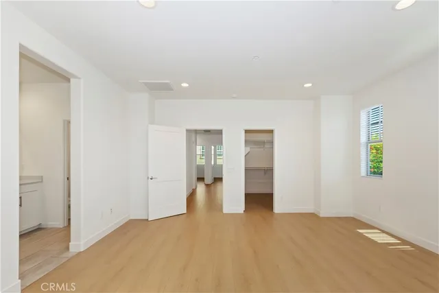 a view of empty room with wooden floor and window