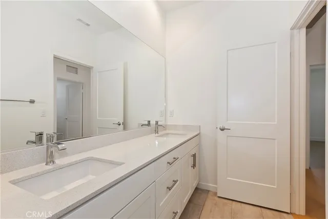 a white bath tub sitting next to a white toilet and vanity