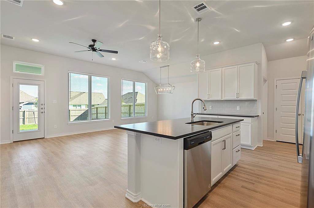 3124 Tarleton Court Bryan, TX 77808 - Photo 6 of 22 a kitchen with granite countertop a sink appliances cabinets and a large window