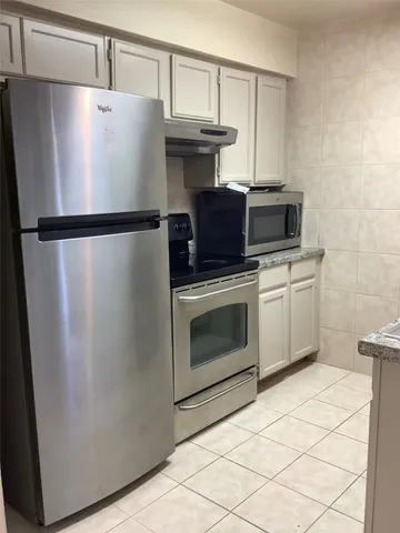 a kitchen with cabinets and stainless steel appliances