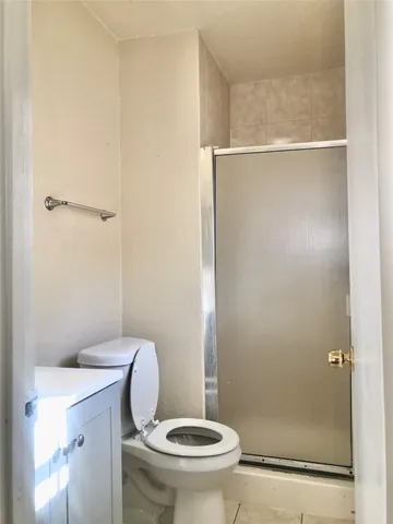 a white toilet sitting next to a shower