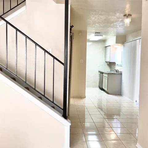 a view of a kitchen with kitchen island wooden floor and staircase