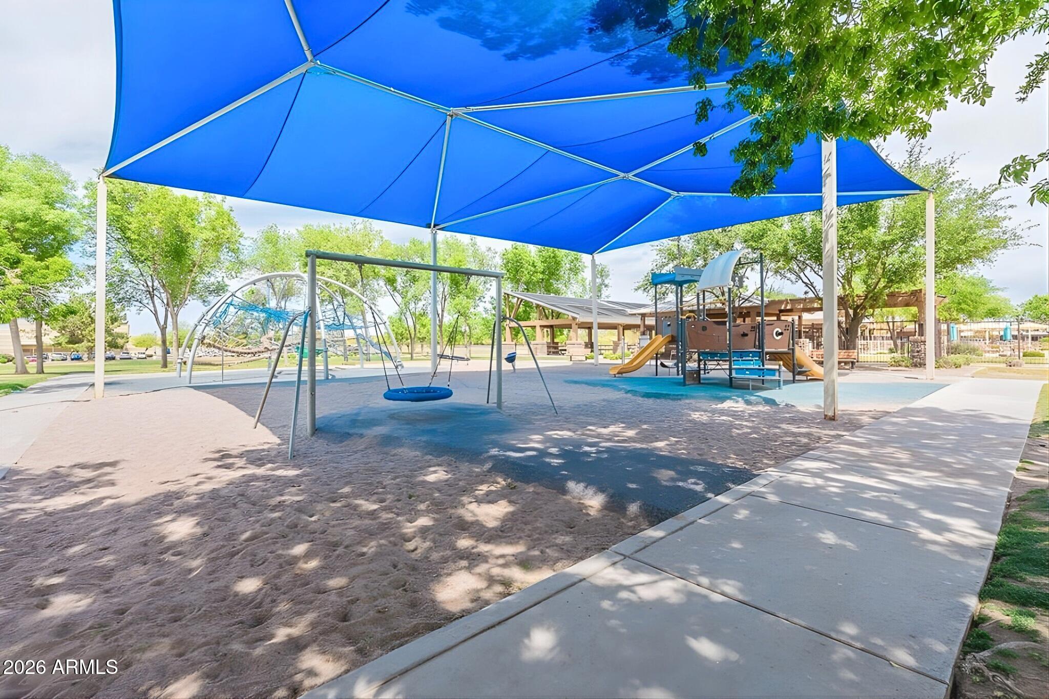 3936 East Blue Sage Road Gilbert, AZ 85297 - Photo 20 of 27 a view of a patio with a table and chairs under an umbrella