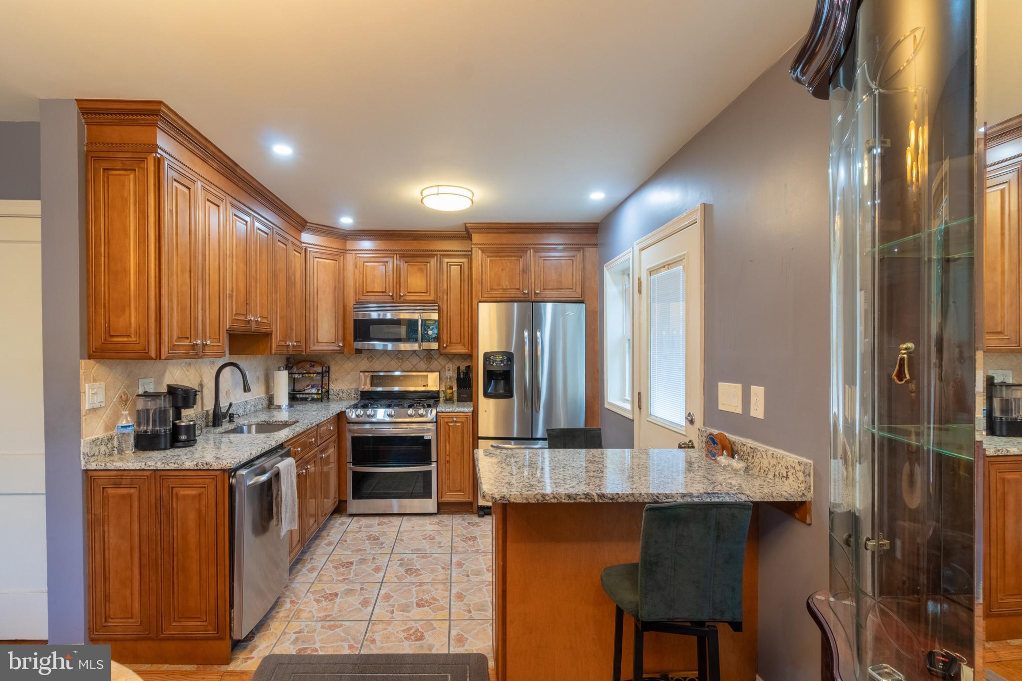 706 Forest Glen Road Silver Spring, MD 20901 - Photo 4 of 40 a kitchen with refrigerator a sink and chairs