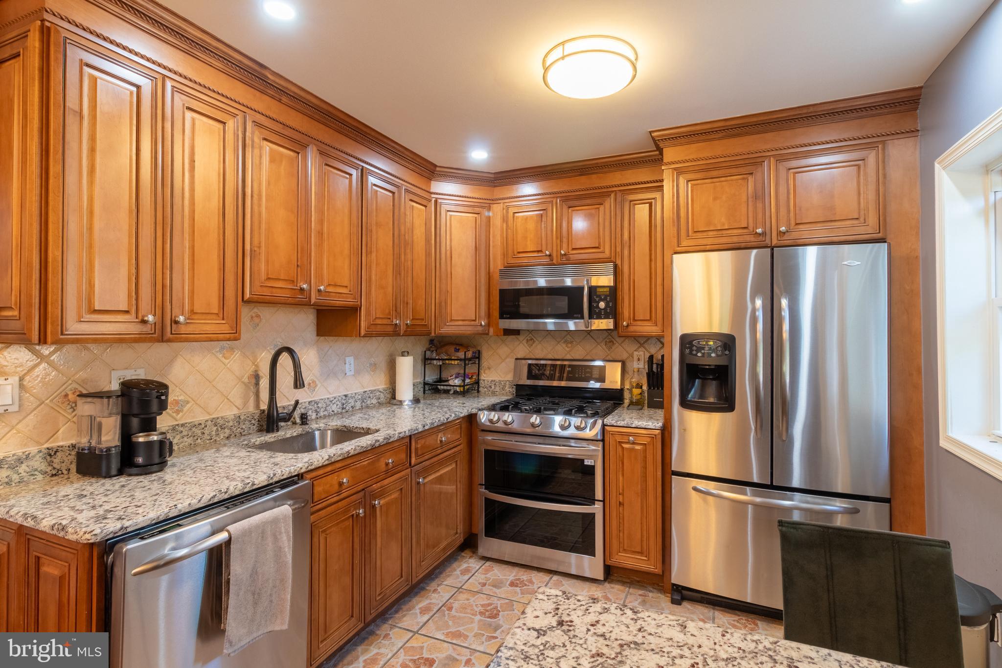 706 Forest Glen Road Silver Spring, MD 20901 - Photo 7 of 40 a kitchen with stainless steel appliances granite countertop a refrigerator stove microwave and sink