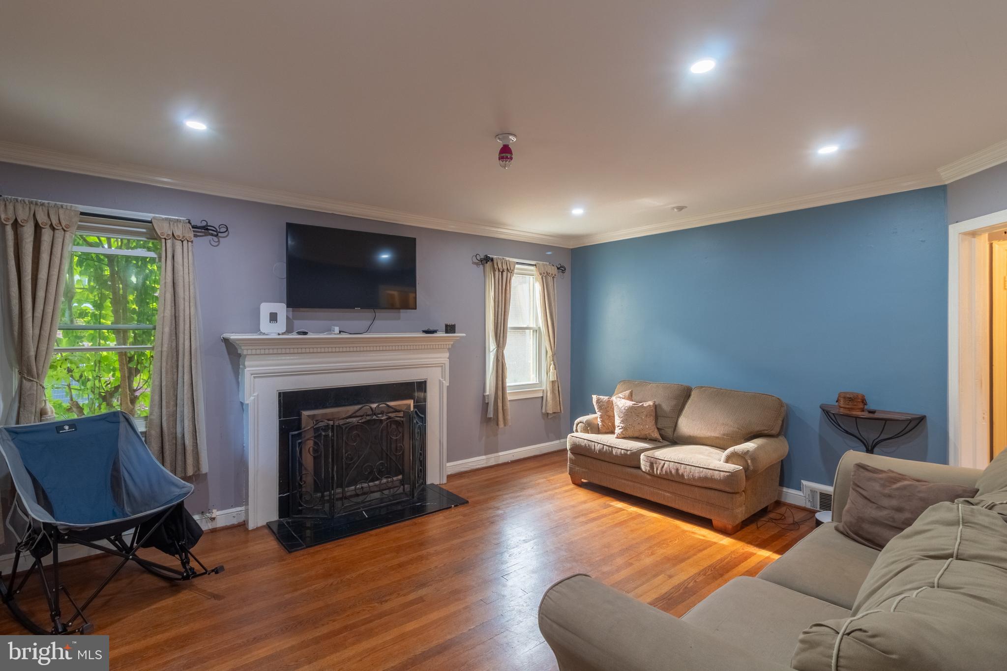 706 Forest Glen Road Silver Spring, MD 20901 - Photo 9 of 40 a living room with furniture flat screen tv and a fireplace
