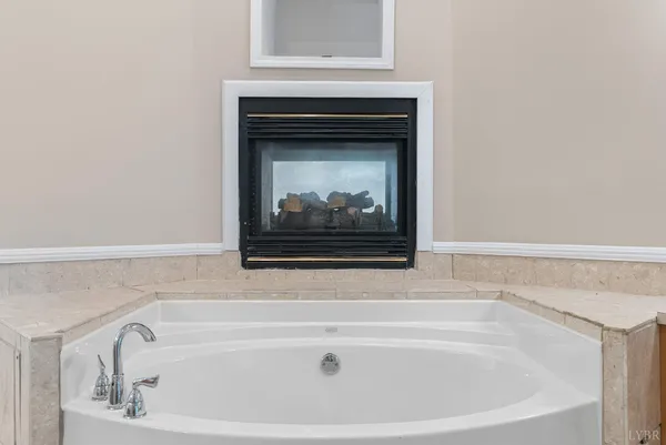 a bathroom with a toilet sink and a large mirror next to a window