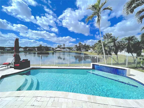 a front view of a house with a yard and lake view