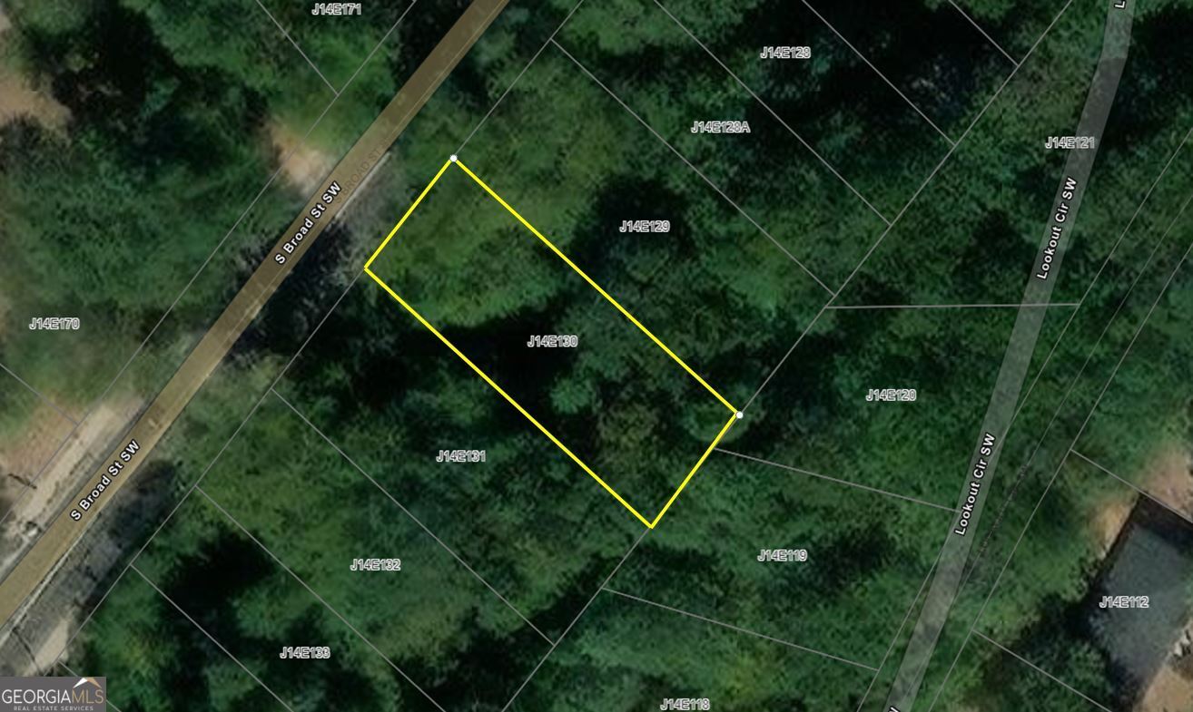 a backyard of a house with lots of green plants and plants