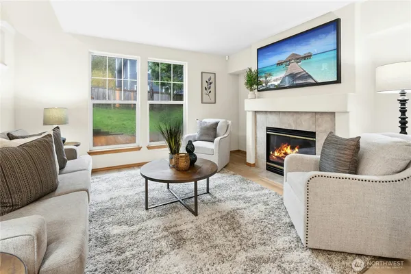 a living room with furniture a fireplace and a flat screen tv