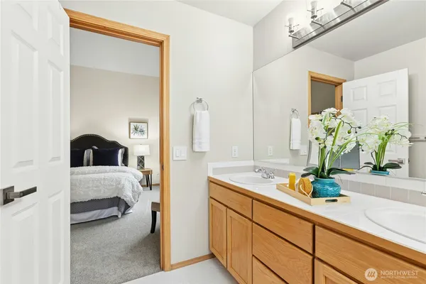 a en suite bathroom with a double vanity sink and large mirror