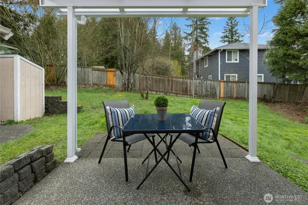 a view of a chair and table in backyard of the house