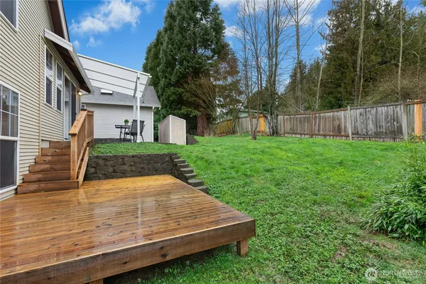 a view of a backyard with wooden fence